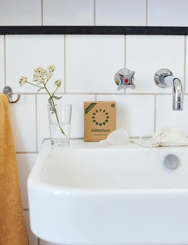 Banyo küvetinin kenarında OrganiCup kutusu